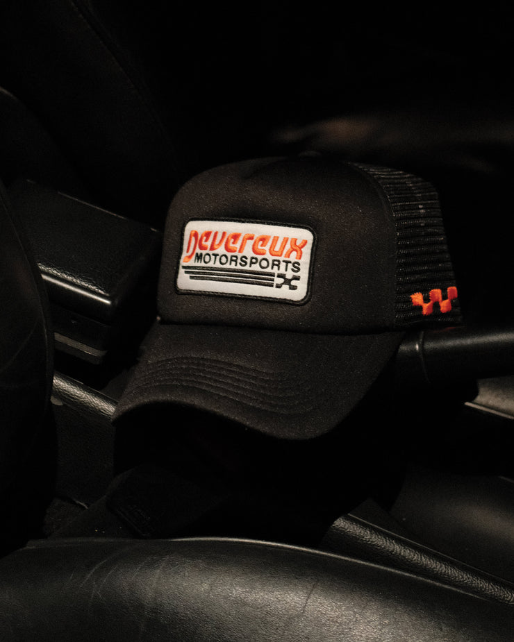 Black cap with a logo on a car seat