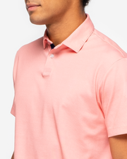 Orange pink coral golf performance polo with navy blue collar detail and two button placket p