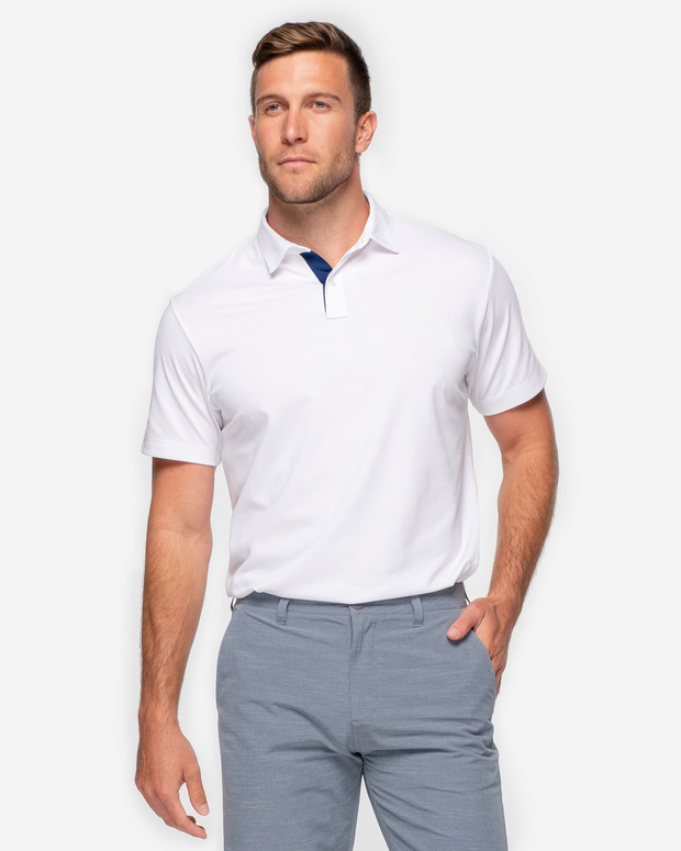 Classic white golf performance polo with navy blue collar detail and two white button up placket paired with grey shorts