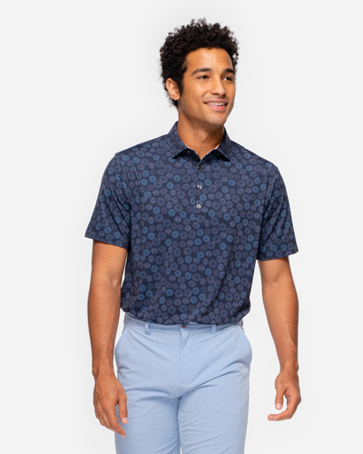 Navy blue Devereux golf polo with orange and blue circular all over print and peach inner collar