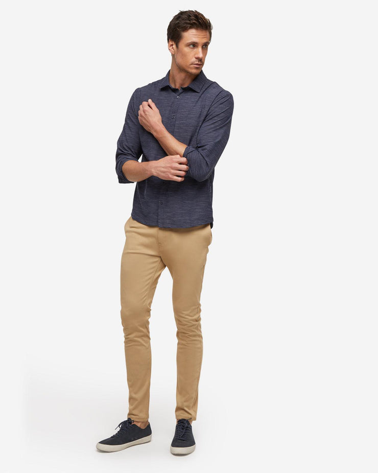 Dark navy blue breathable and stretchy long sleeve button down paired with khaki pants