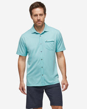 Turquoise blue textured short sleeve button down with asymmetric left chest pocket with button paired with dark grey shorts